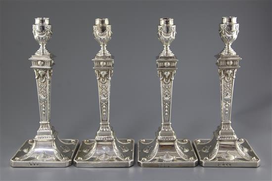 Two pairs of George III silver Adam style candlesticks, weighted.